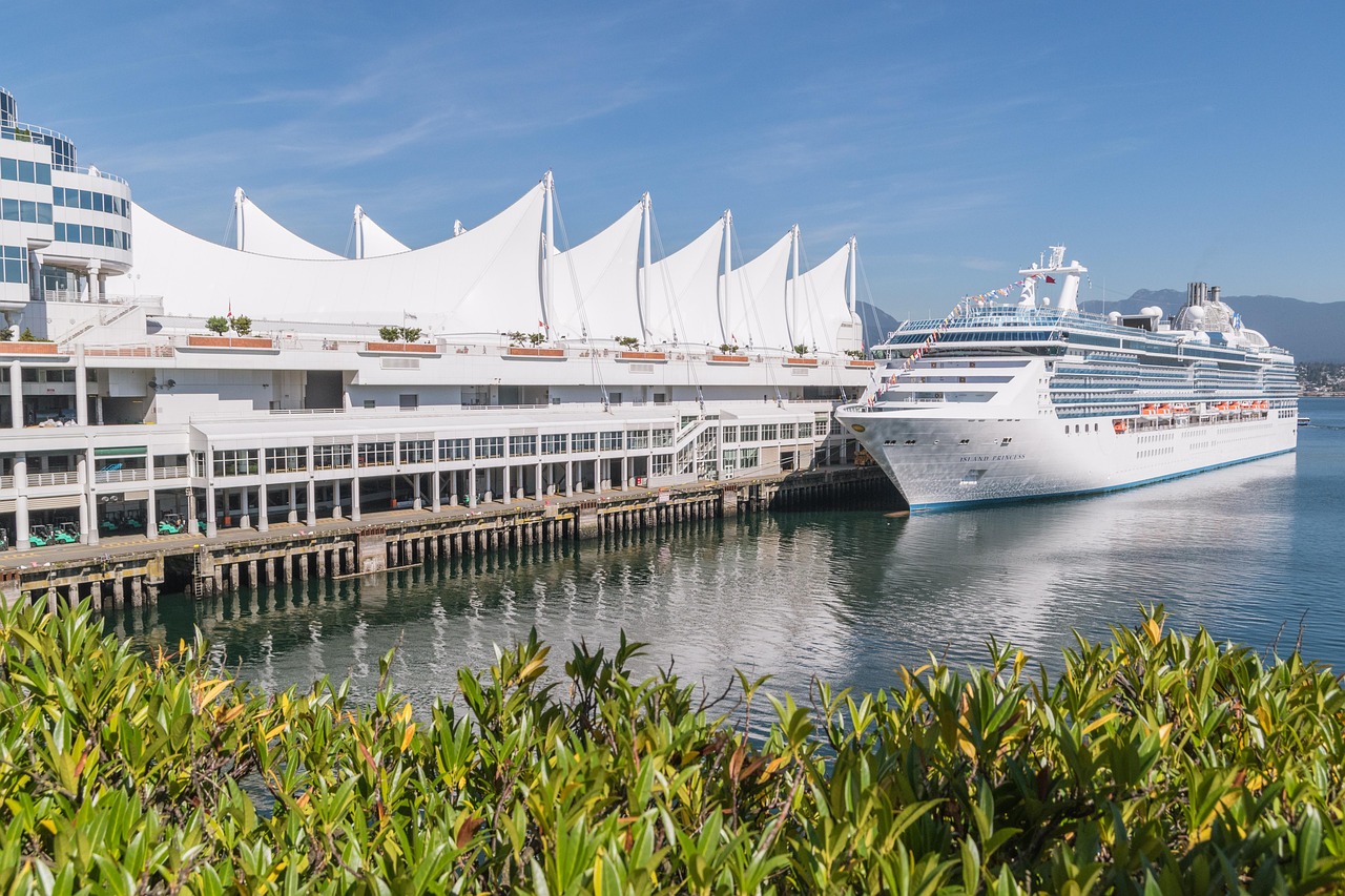 Canada Place cruise terminal in Vancouver with the distinctive white sail-shaped roof structures and cruise ship docked at the pier — the starting and ending point for most private Vancouver transfer-day tours